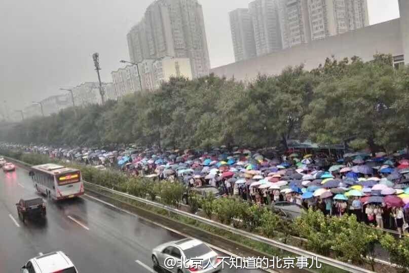 雨天早高峰的北京地铁1号线地铁站外的雨伞-1